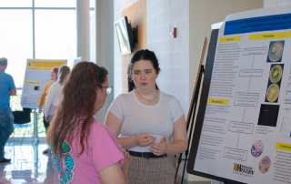 student explains research poster