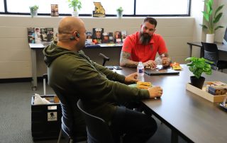 student eats with wounded warrior rep