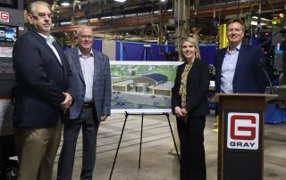 NCMC, Gray Manufacturing and Missouri Western officials on factory floor with artists conception of CTAC