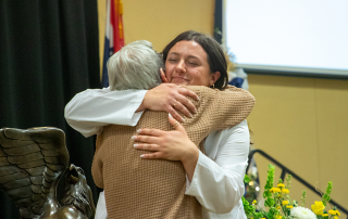 nursing student hugs family member at pinning ceremony