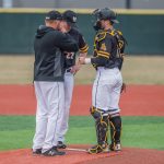 A strategic meeting takes place between coach, pitcher and catcher.