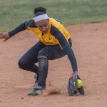 Lonnie Groves stopping the ball before throwing an out to first