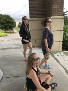 Marisa Steimel, Libby Steimel and Priscilla Steimel(sitting) watching the eclipse from the Clock Tower