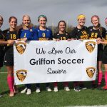 Seniors posing with their banner before the game. The team finished with 17 wins, 5 losses and 0 ties.